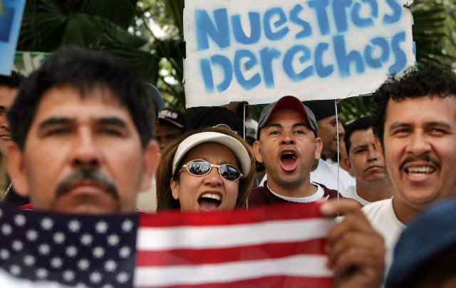 NEW ORLEANS - MAY 01:  Immigrants cheer beneath a sign in Spanish reading "Our Rights" at an immigrants rights rally and march May 1, 2006 in New Orleans, Louisiana. Immigrants and their supporters around the nation are rallying together through marches and demonstrations, along with boycotting work and spending, in a consolidated effort to show their importance throughout American society as the ongoing political debate on immigration reform continues.  (Photo by Mario Tama/Getty Images)