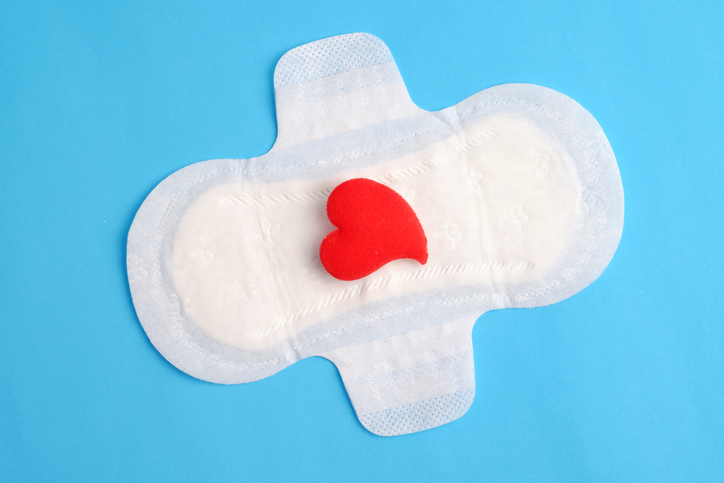 Woman hygiene protection of sanitary pad on blue background, woman menstruation cycle, critical day and red heart concept.